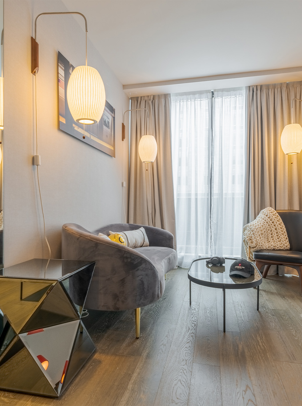 A Junior Suite with Balcony and View do Pestana CR7 Times Square tem uma sala de estar com um sofá, janelas grandes e cadeira