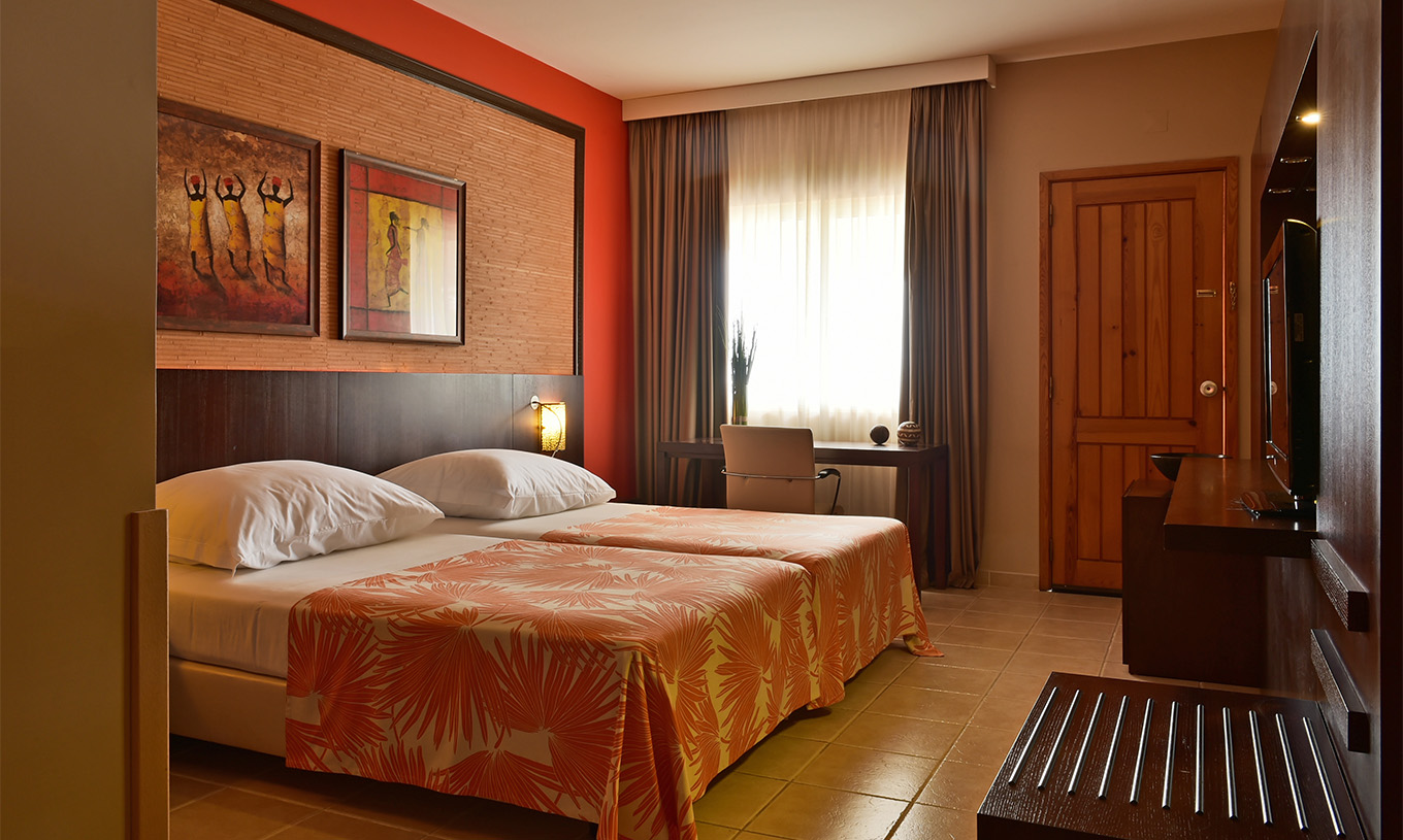 O quarto Premium do Pestana Tropico conta com duas camas individuais, televisão e secretária com cadeira