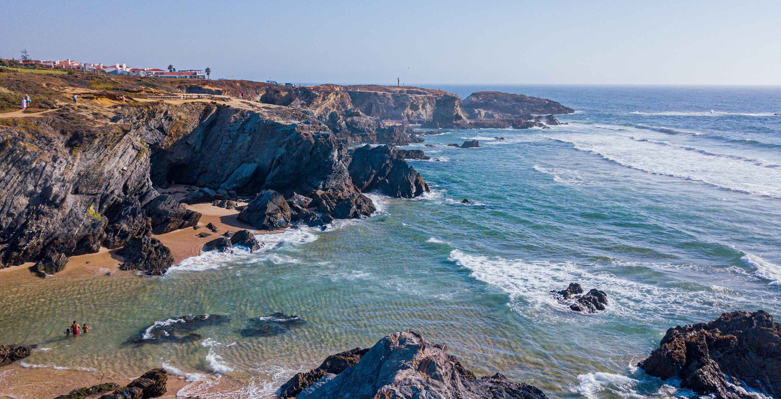 Vista aérea das falésias e do mar junto ao Pestana Porto Covo Village, com pequenas praias e águas cristalinas