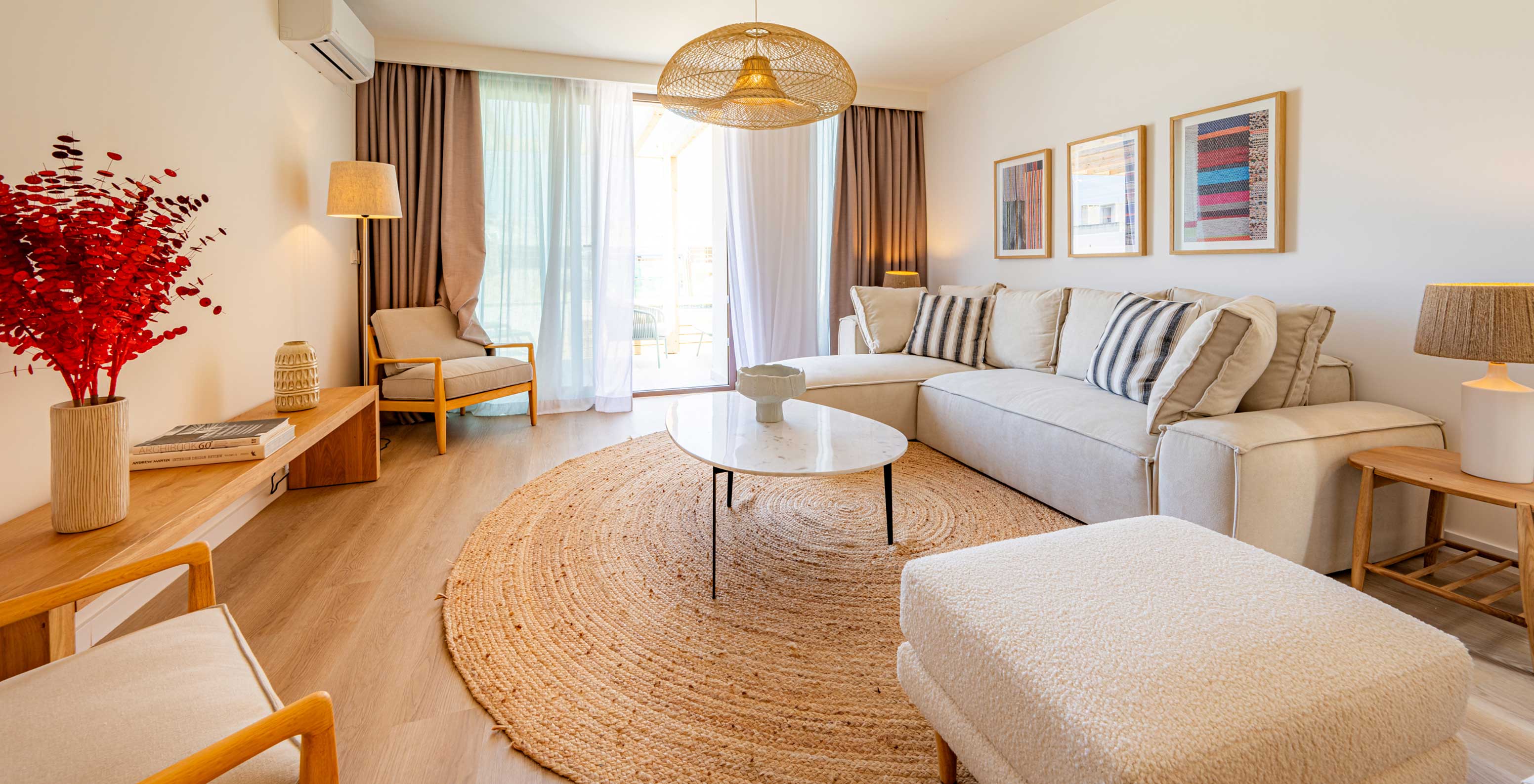 Sala de estar do Pestana Porto Covo Village com sofá bege, mesa redonda branca e decoração em tons neutros