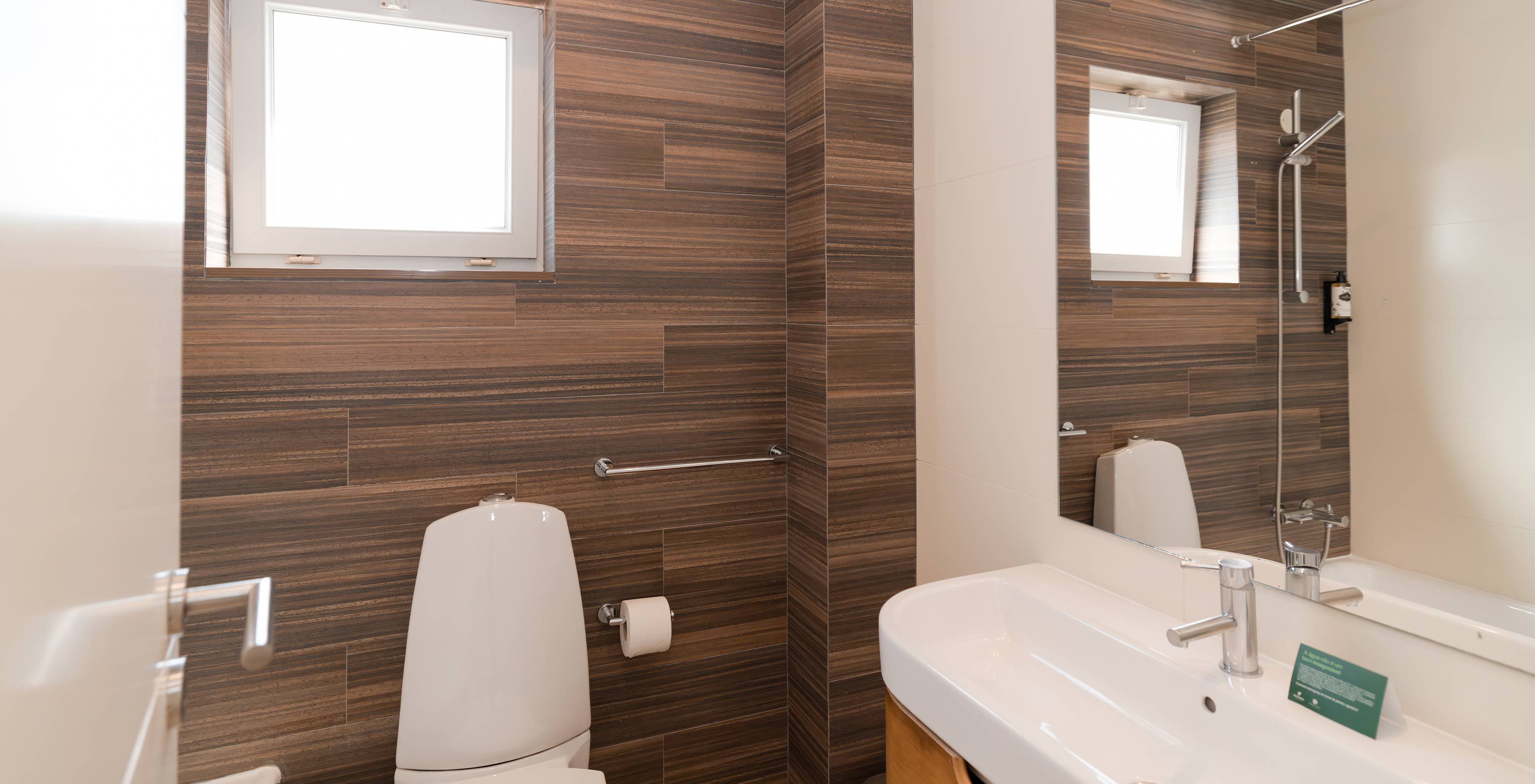 A Villa 1 Quarto Vista Jardim do Pestana Alvor Beach Villas tem uma casa de banho com lavatório, espelho e uma pequena janela