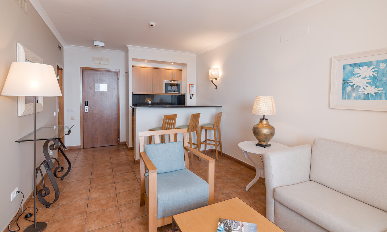 A Suite Vista Mar do Pestana Viking tem uma sala de estar com sofá e poltronas, e uma pequena cozinha com microondas