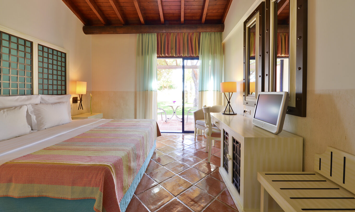 A Suite Vista Jardim Vila Sol do Pestana Vila Sol - Vilamoura tem um quarto com cama de casal, espelhos e janela com varanda