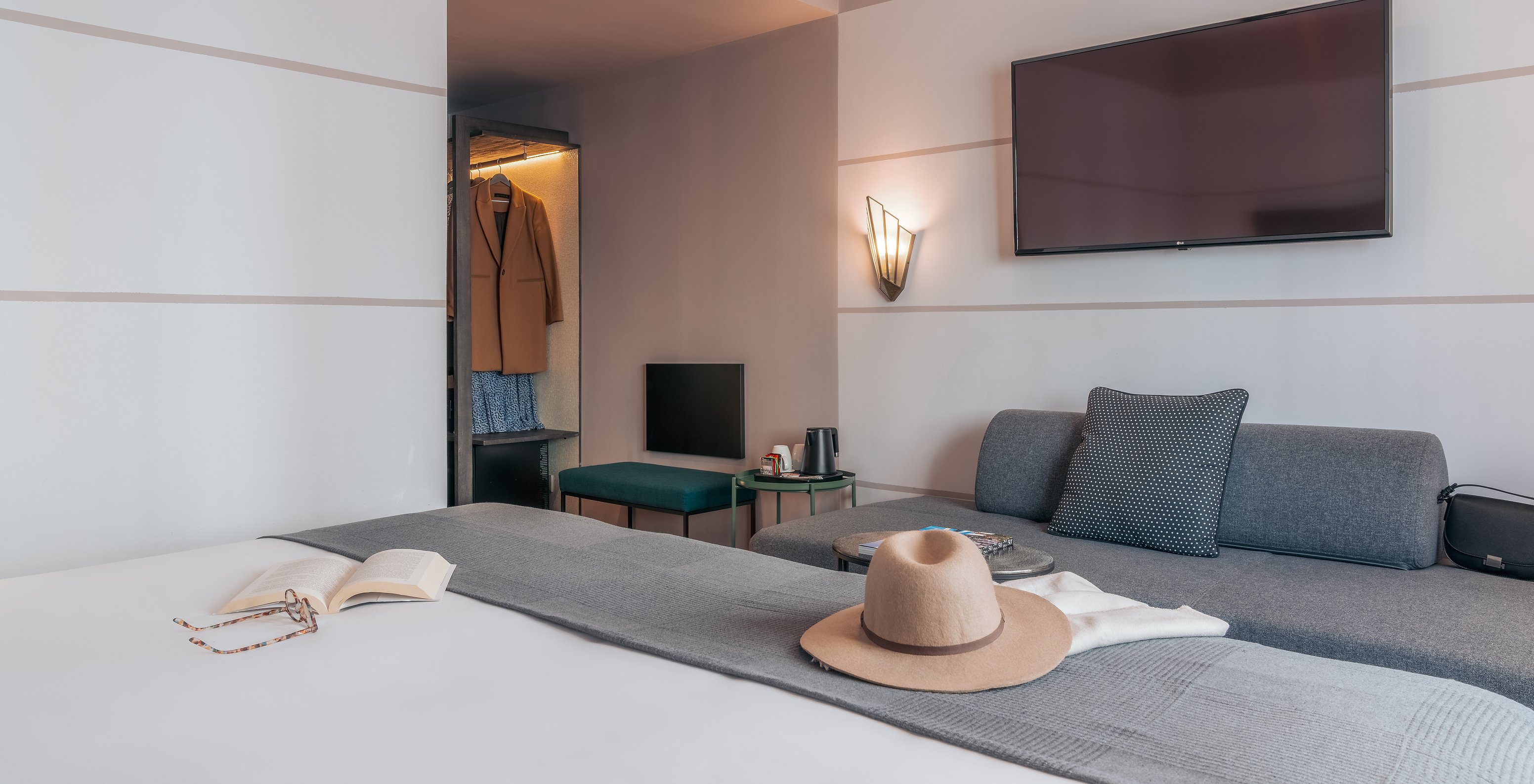 O Double Classic do Pestana Lisboa Vintage tem uma cama de casal com uma manta cinzenta, um sofá cinzento e uma televisão