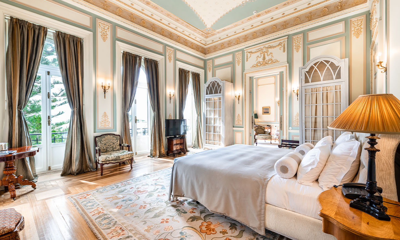 A Suite D. Manuel/ D. Luís Filipe do Pestana Palace Lisboa tem um quarto grande com três janelas com vista para o jardim