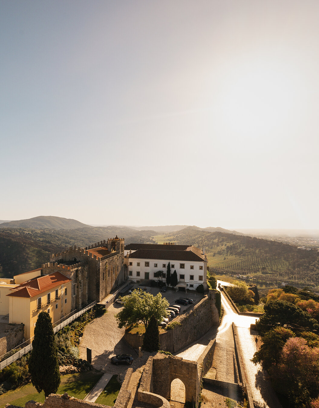 Vista panorâmica da Pousada Castelo Palmela, Hotel com Vista para a Serra da Arrábida, com um castelo com muralhas e torres 