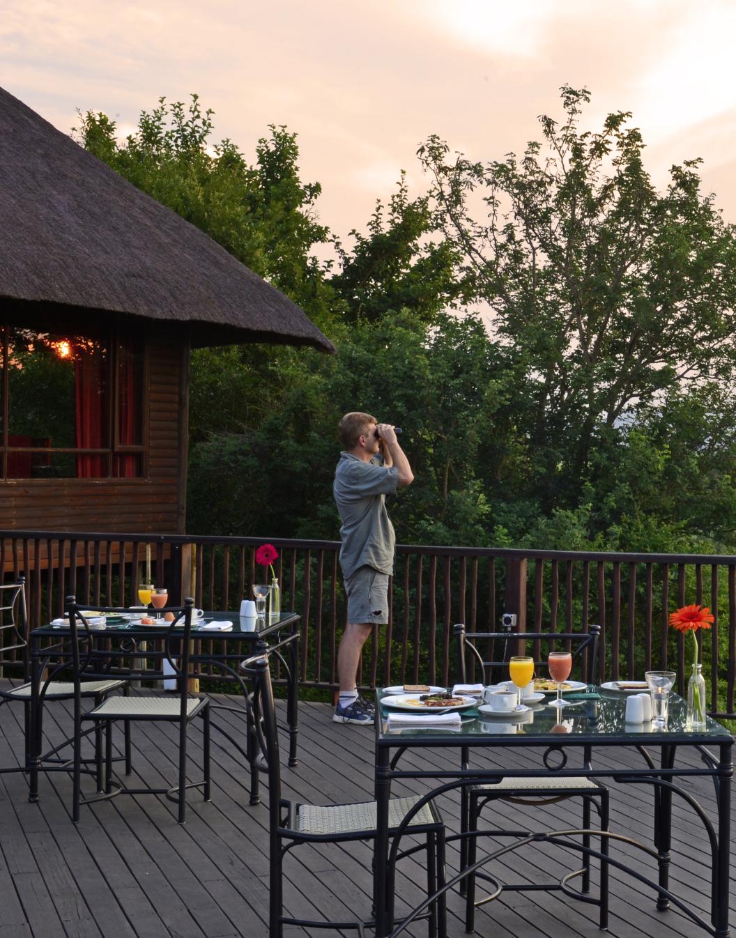 Pestana Kruger Lodge, hotel de 4 estrelas no Kruger Park, com mesas na varanda onde é possível fazer refeições e ver animais