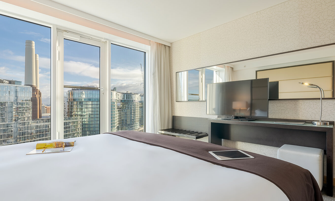 O Superior King do Pestana Chelsea Bridge tem cama de casal, uma secretária com televisão, sofá e janelas para a cidade