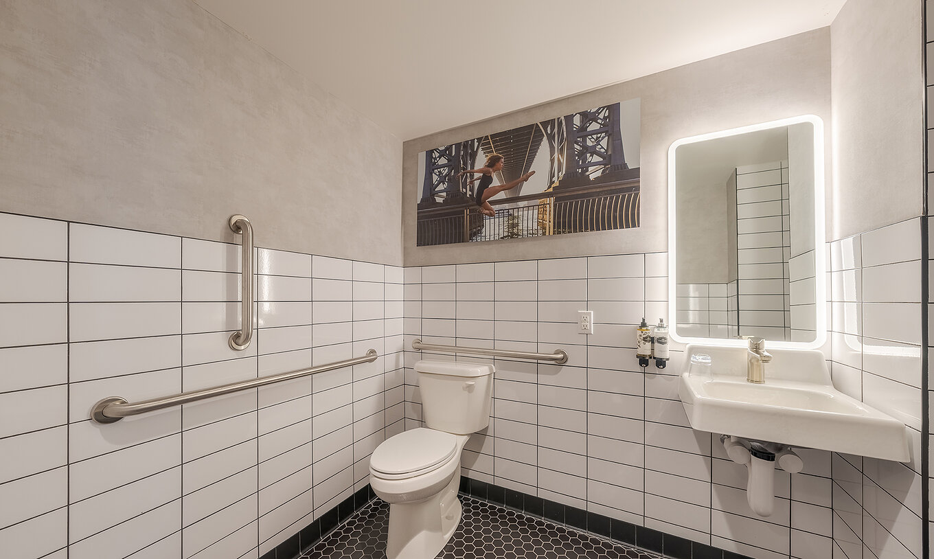 O Comfort ADA do Pestana CR7 Times Square tem uma casa de banho adaptada com sanita, lavatório e espelho