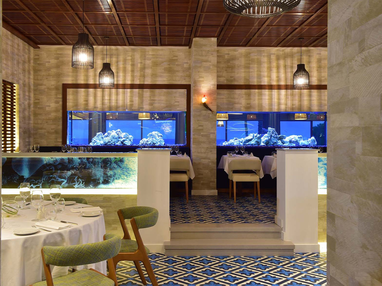 Das Restaurant Sul im 5-Sterne-Hotel an der Algarve hat Aquarien, Deckenleuchten und gepolsterte Stühle