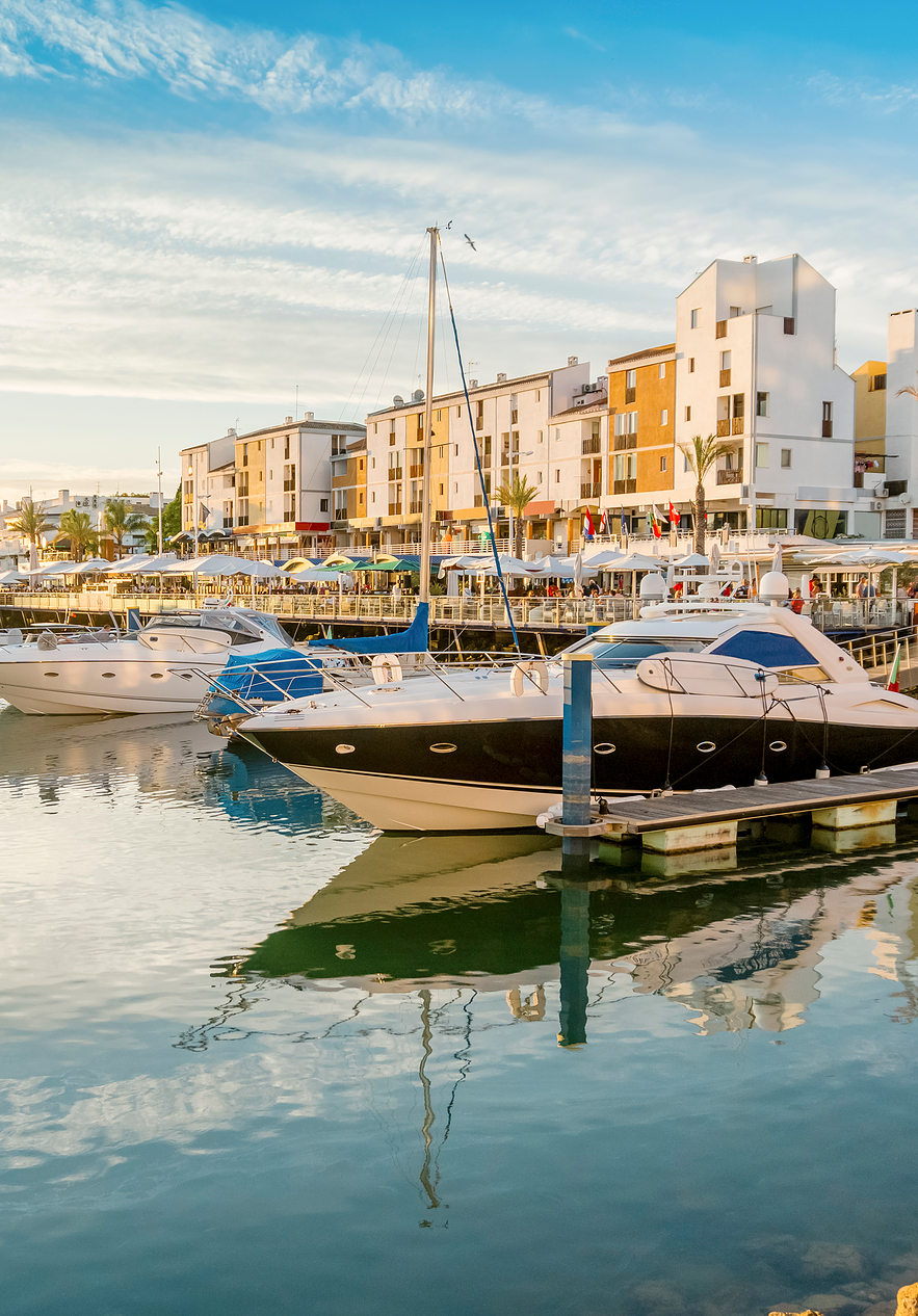 Vilamoura Marina in der Algarve bei Sonnenuntergang, mit ankernden Booten in verschiedenen Größen und ruhigem Wasser