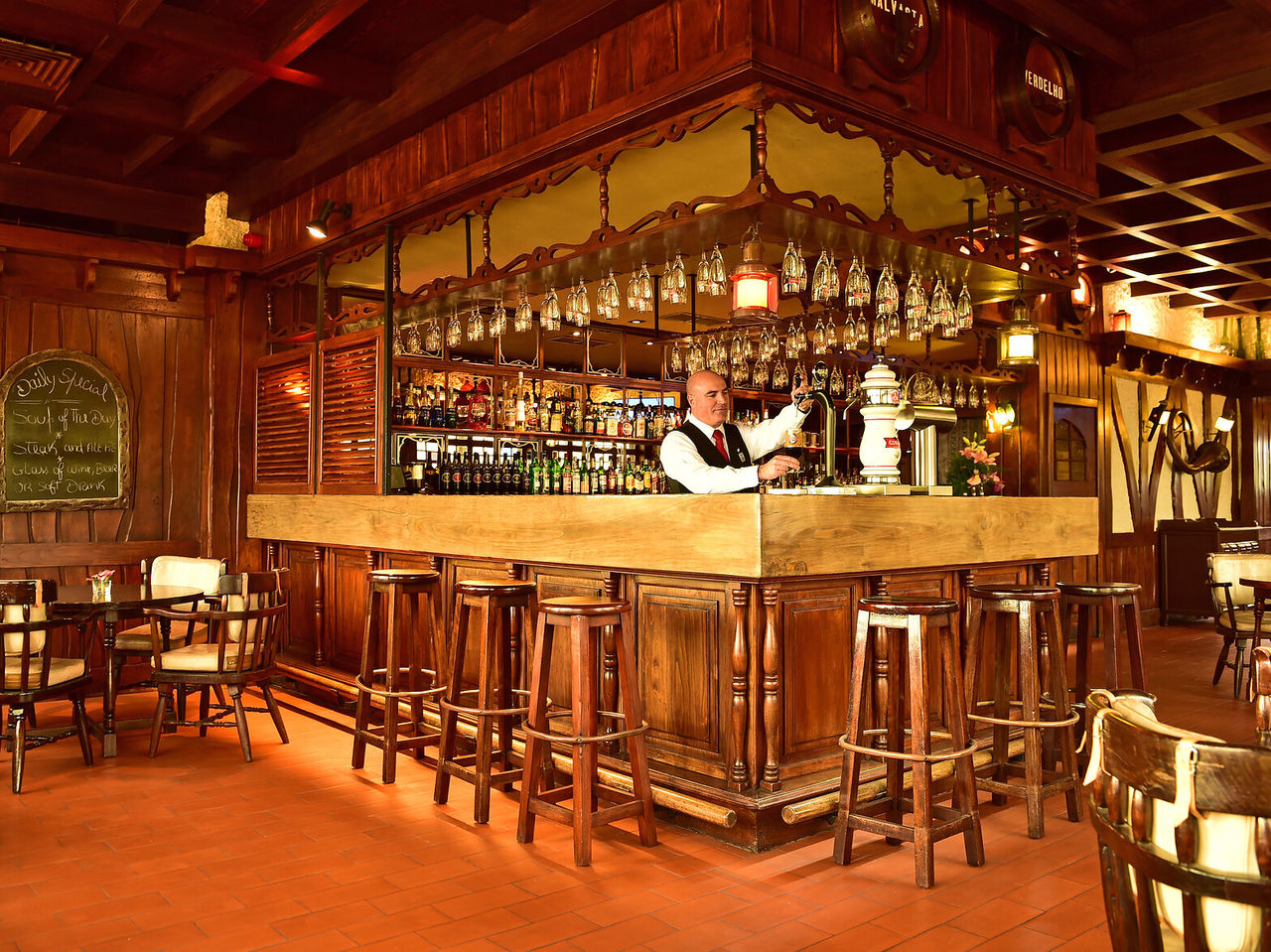 Die Bar The Pub im Hotel im Zentrum von Madeira, hat eine Theke, umgeben von hohen Stühlen und verschiedenen Getränken