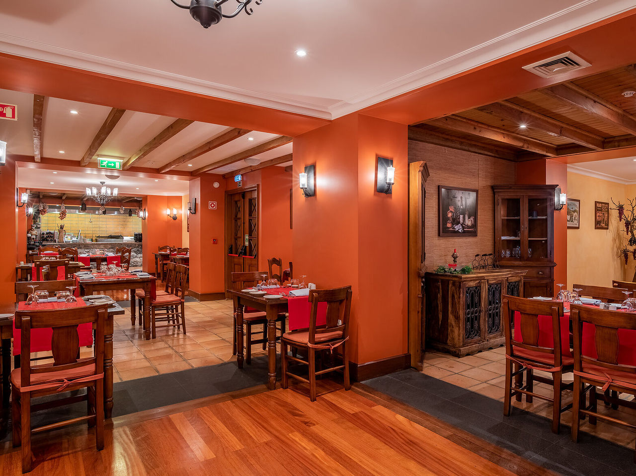 Das Restaurant Adega Madeirense im romantischen Hotel in Funchal, Madeira, hat antike Dekoration und orange Wände