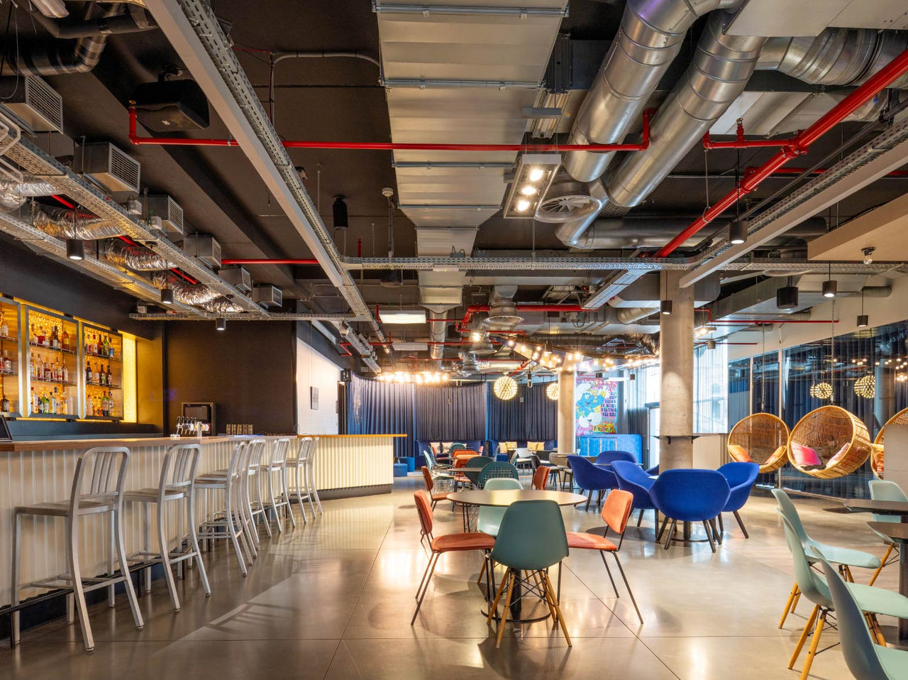 Le bar de l'hôtel à Bruxelles près du Parlement européen a un comptoir avec des tabourets hauts et des tables rondes avec chaises
