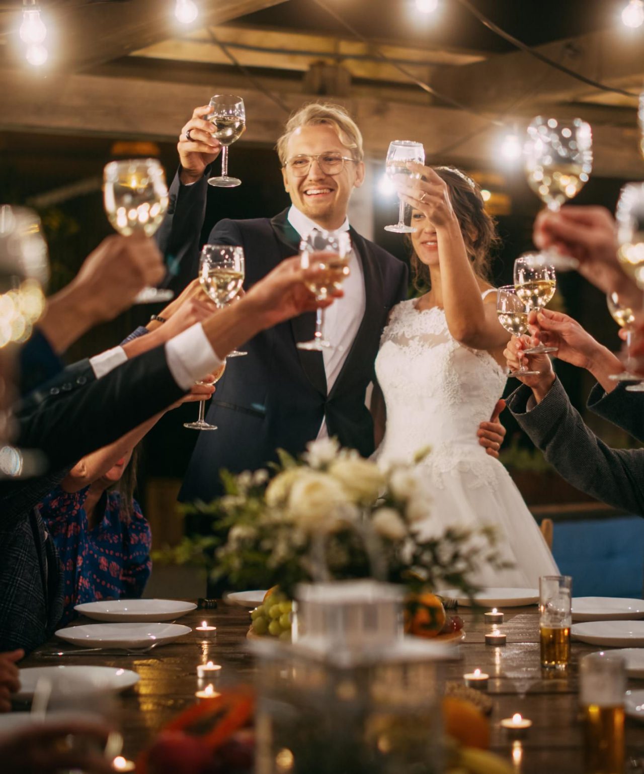 Het pasgetrouwde stel viert hun huwelijk, toostend met hun gasten aan een elegante tafel met een bloemstuk