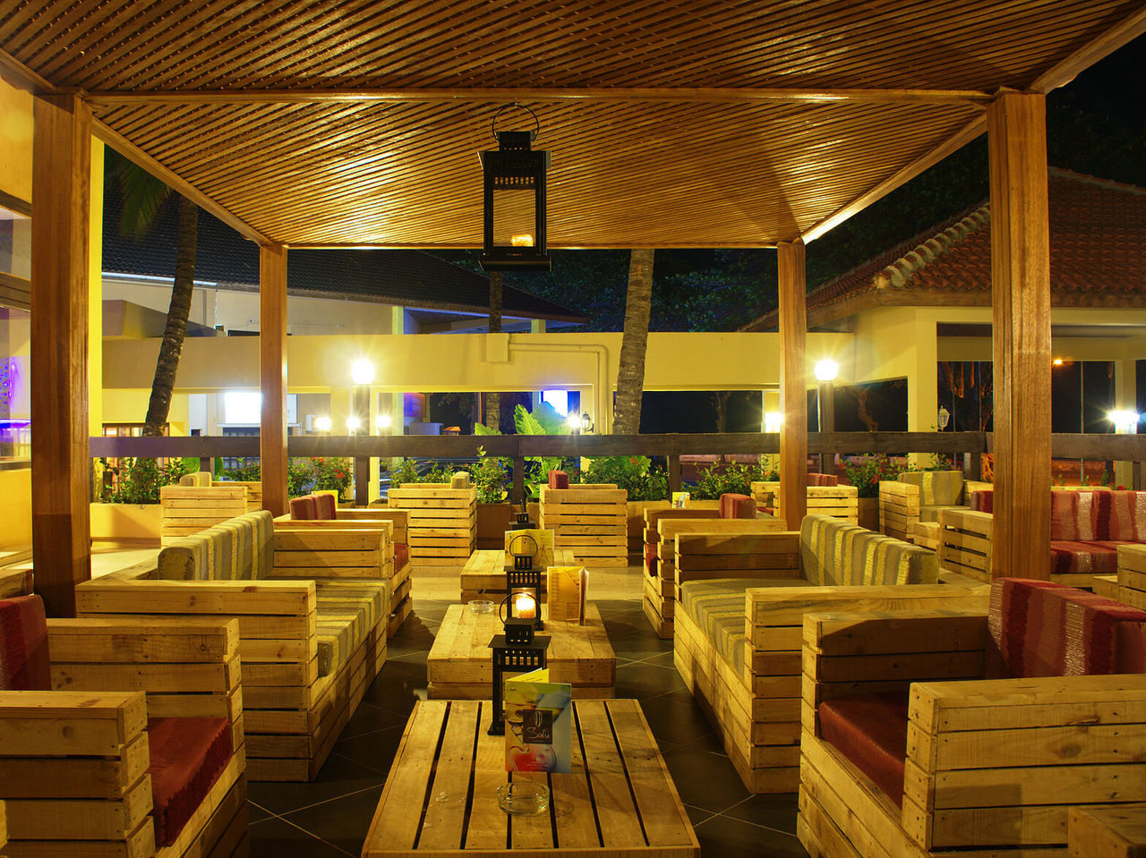 De bar Safu, van het 4-sterrenhotel in São Tomé, heeft verschillende tafels met houten banken en kleurrijke kussens