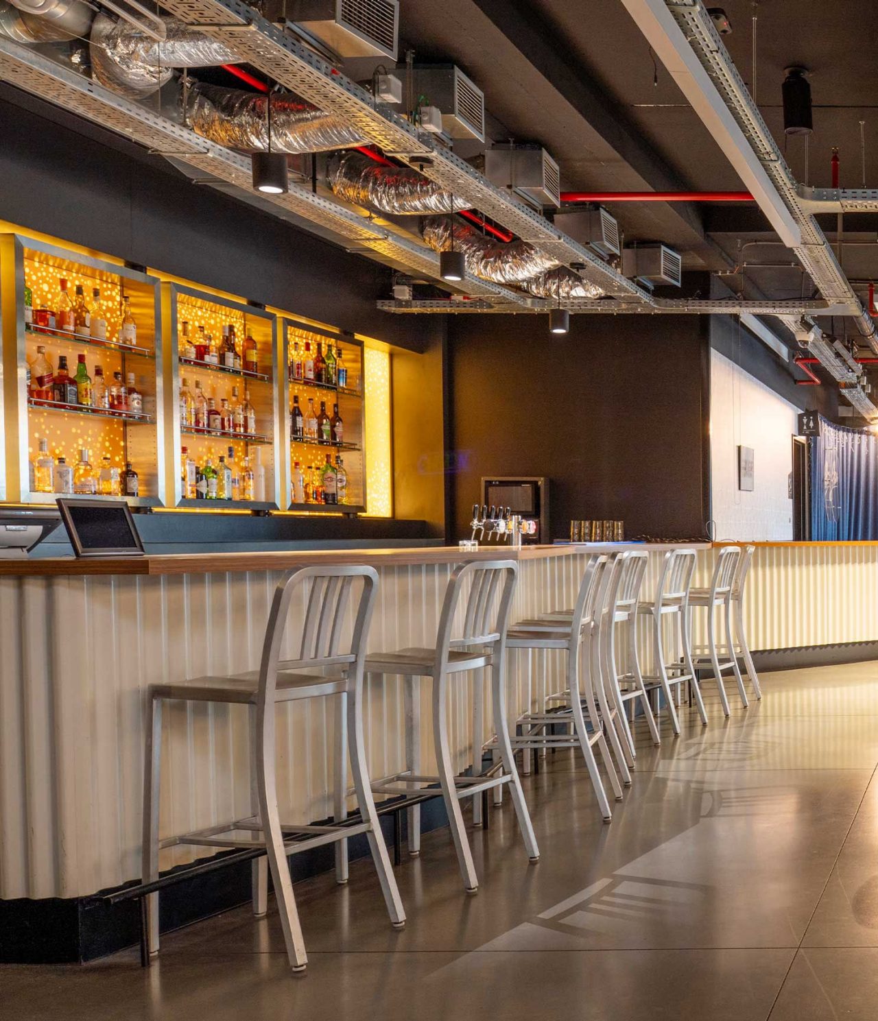 De bar van het hotel in Brussel vlakbij het Europees Parlement heeft een bar met hoge krukken en ronde tafels met stoelen