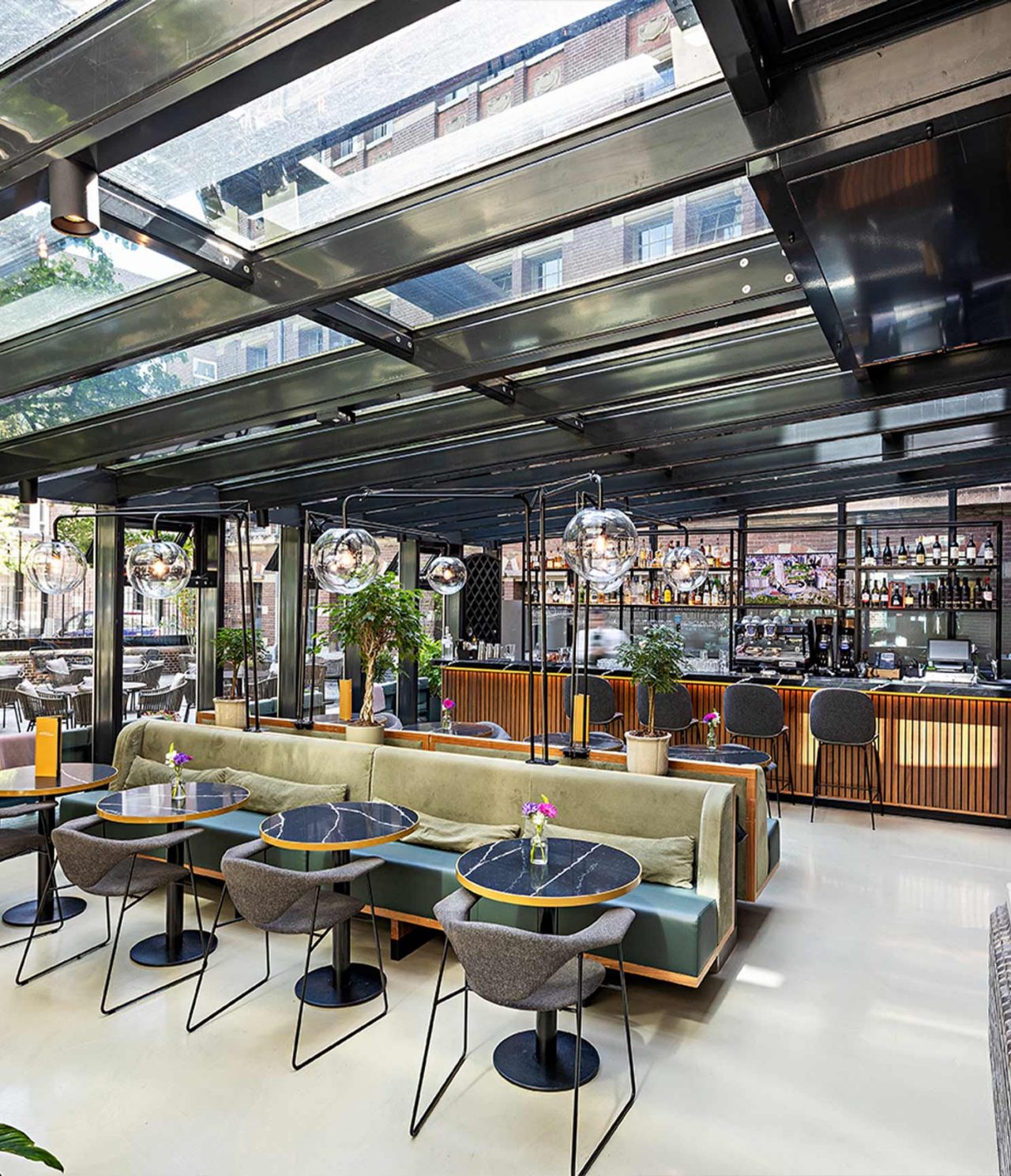 Bar van Pestana Amsterdam Riverside 5‑Sterrenhotel in Amsterdam met glazen dak en stijlvolle zitplaatsen