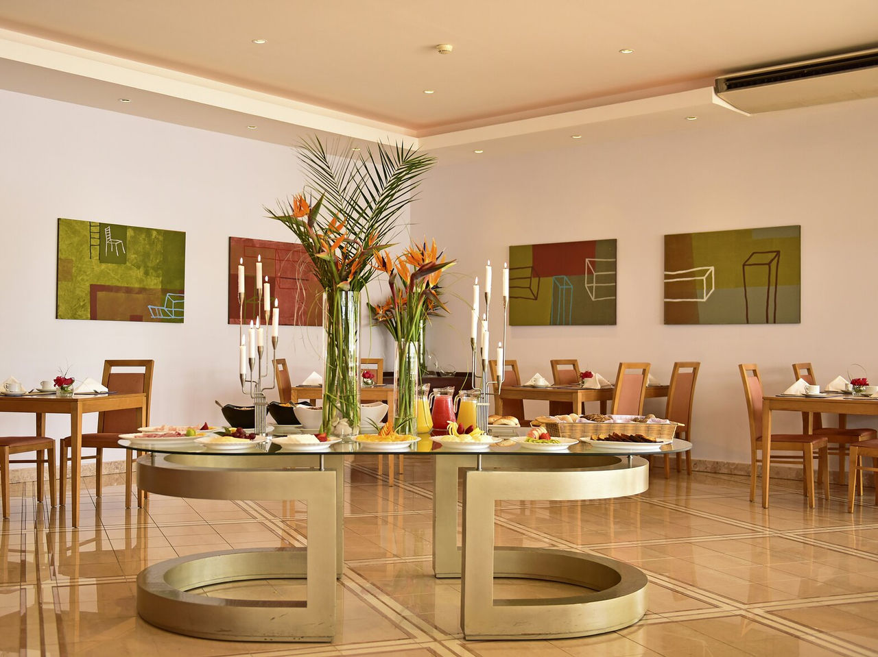 Het Restaurant A Adega, Aparthotel in Algarve, heeft verschillende tafels met decoratie, eten en bloemen in het midden
