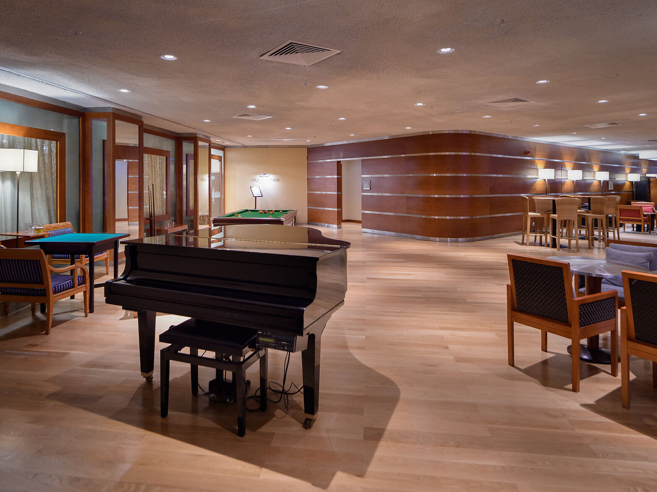 De bar Prime, van het 5-sterrenhotel in Vilamoura, heeft een ruime ruimte met tafels, stoelen en een piano