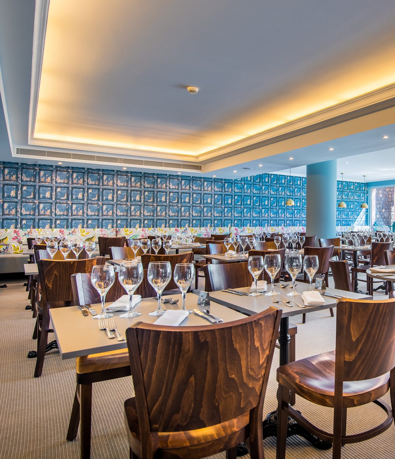 Het restaurant Campo de Fiori, van het hotel in Funchal, heeft een ruime ruimte met kleurrijke muren, tafels en stoelen