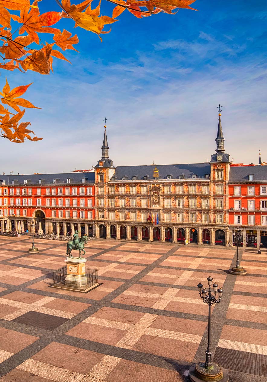 Uitzicht op de Plaza Mayor in Madrid, met oranje historische gebouwen en een groot centraal plein