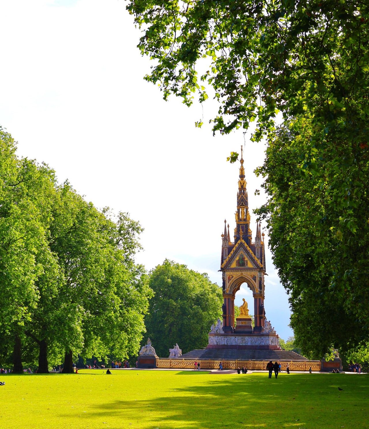 Uitzicht op een historisch monument in Londen, met een gouden standbeeld in het midden en een toren met gouden details