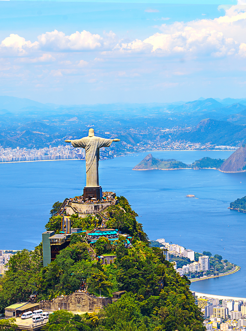 Icônica estátua do Cristo Redentor no Rio de Janeiro, com a cidade, o oceano e a praia de fundo