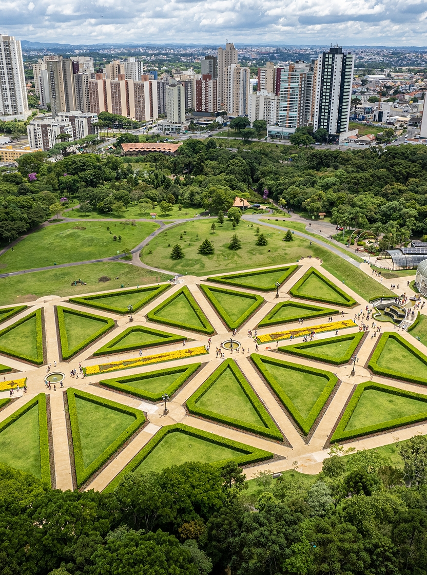 Vista aérea de Curitiba com parques verdes exuberantes e arquitetura moderna e imponente