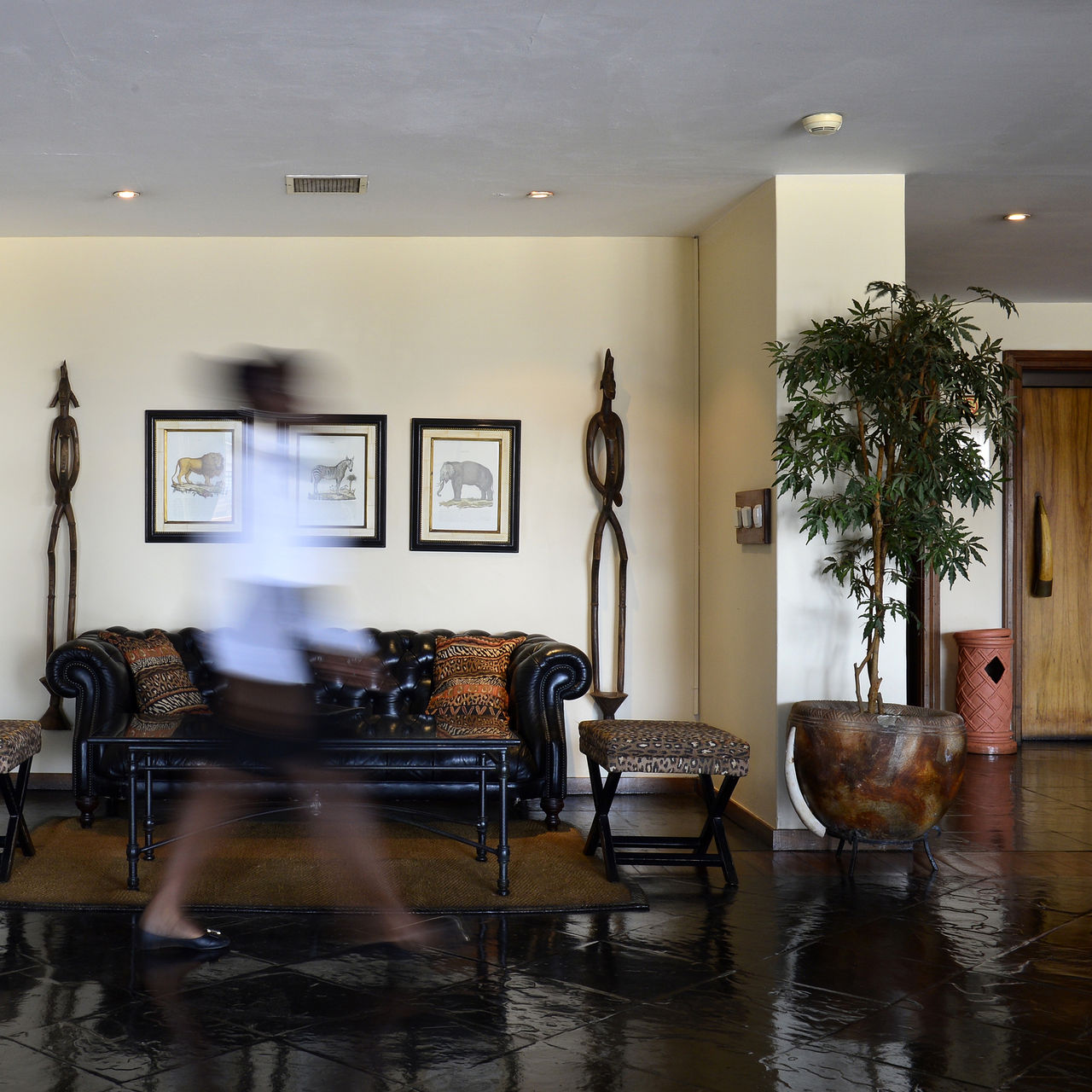 Lobby with a black sofa and two vases with typical African decor at Pestana Rovuma, a 4-star hotel in Maputo