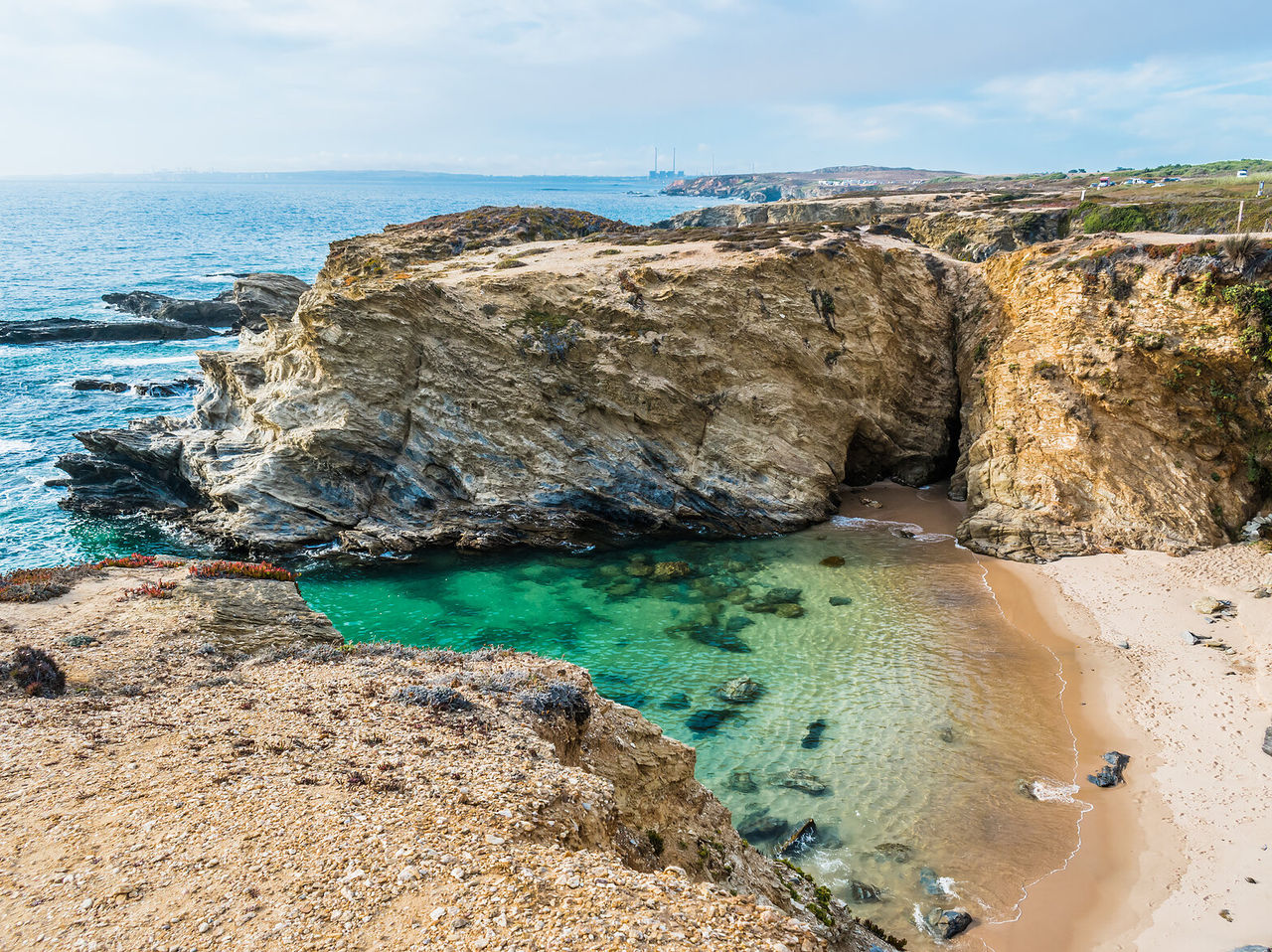 Hidden beach between cliffs in Alentejo, with crystal-clear waters and white sand, ideal for relaxing