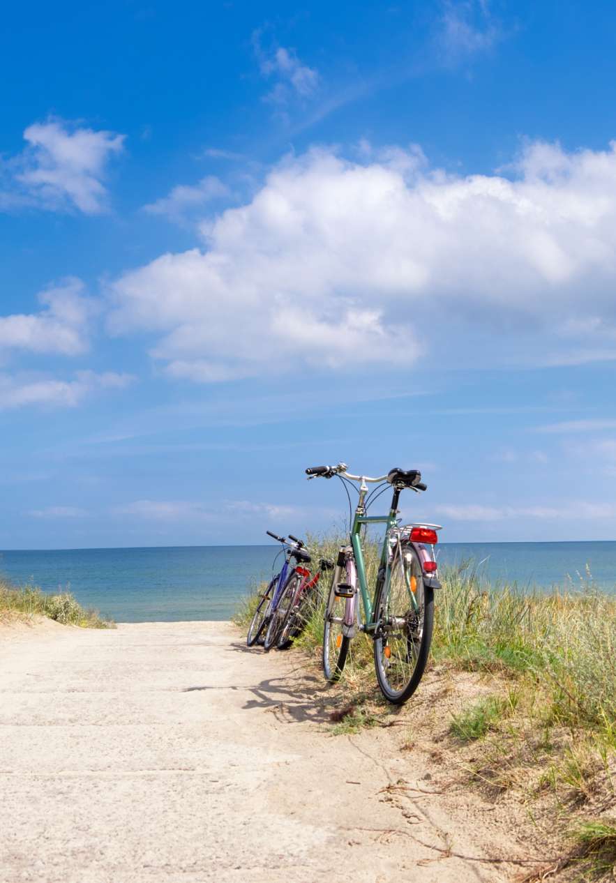 Two bicycles parked by the roadside near the beach, after a long bike ride
