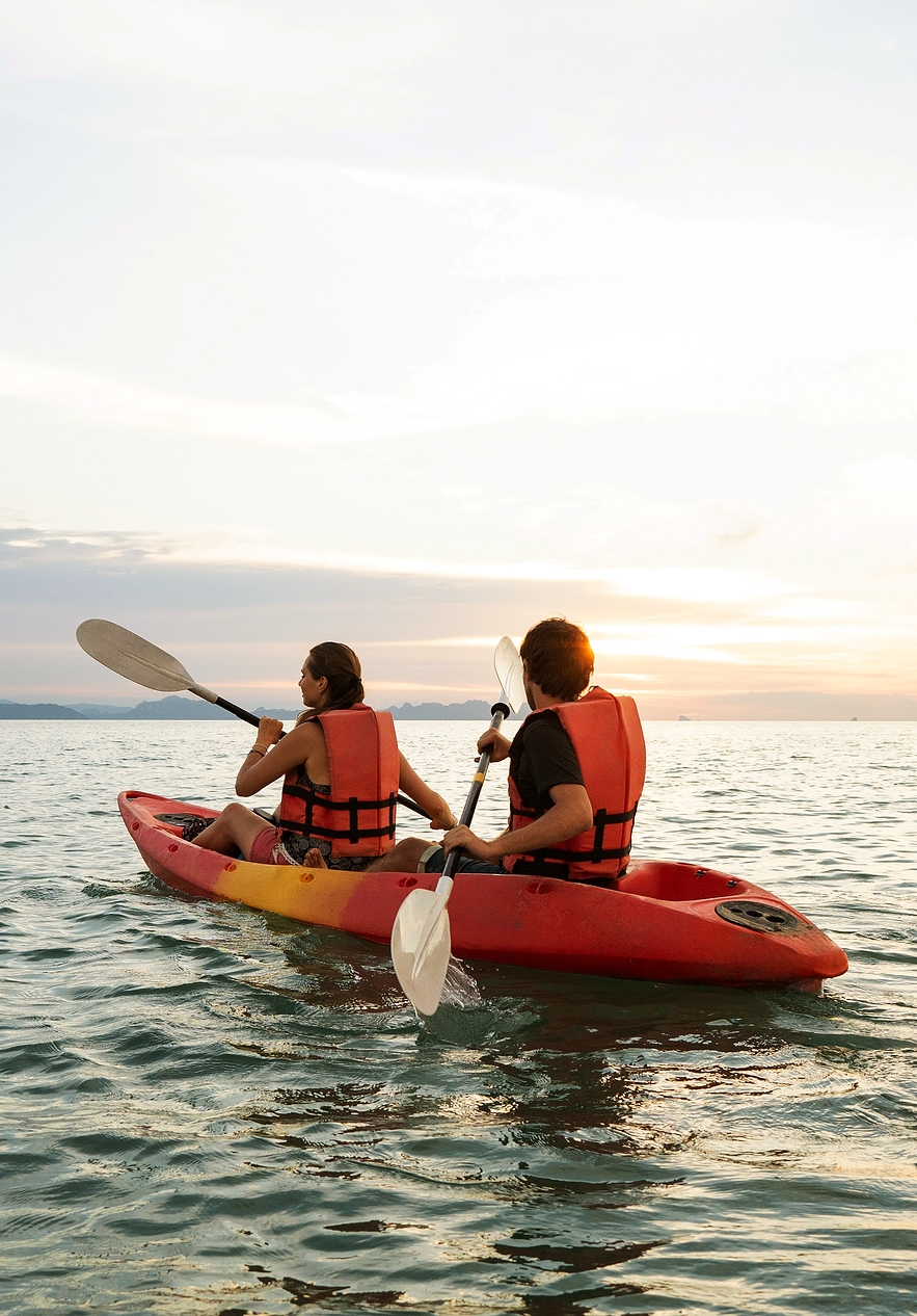 Two people rowing in a kayak in the calm sea of Tróia