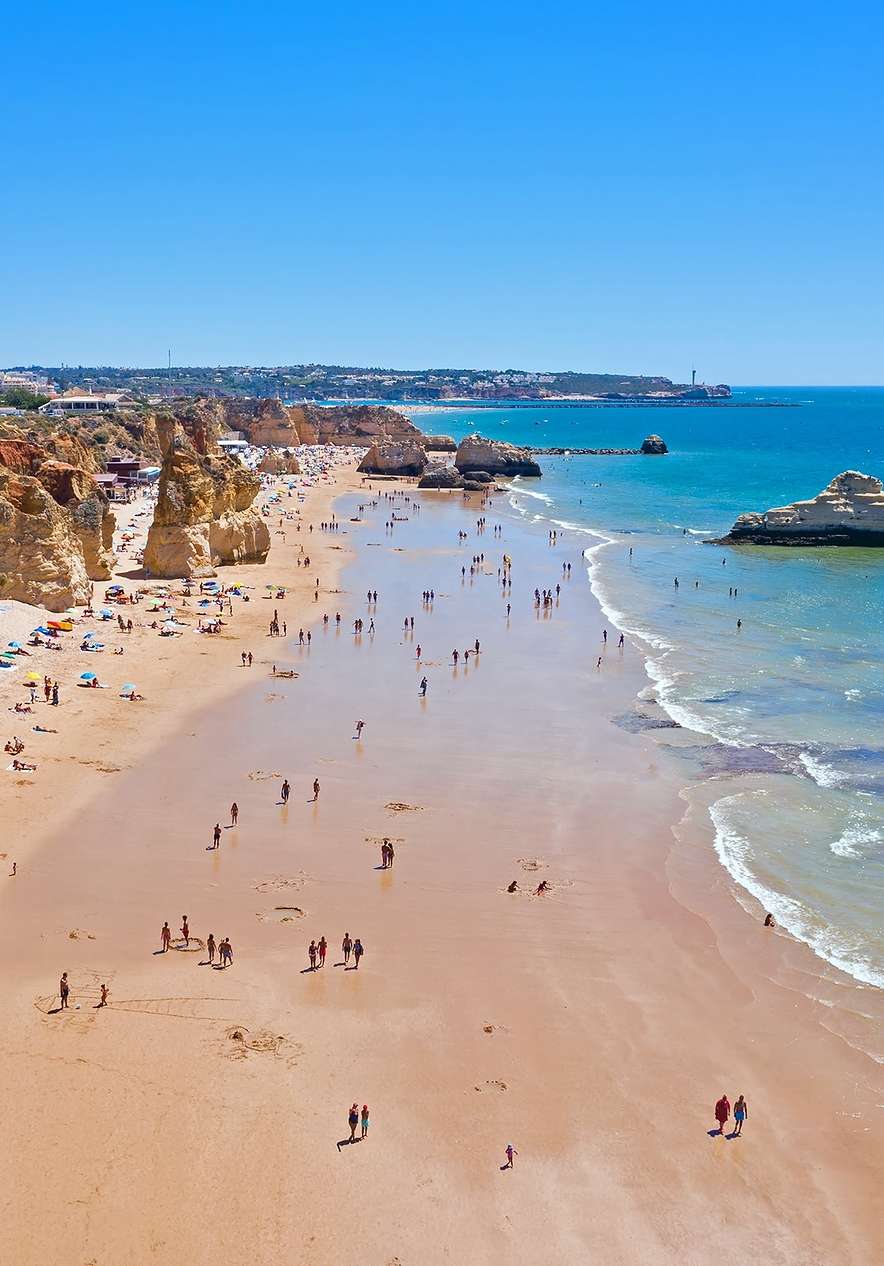 Visit Praia da Rocha with several rocks scattered across the sand that meet the blue waters of the Algarve