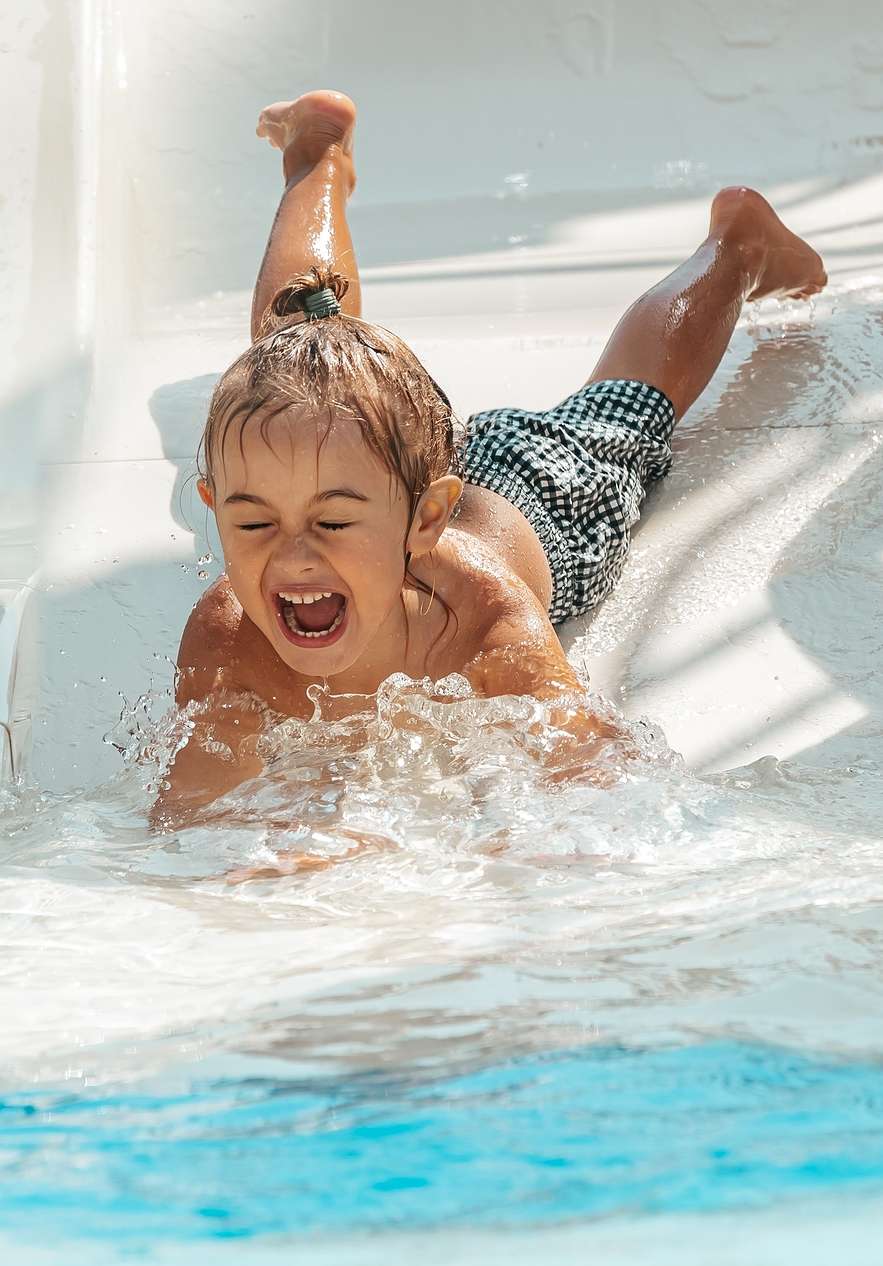 Child smiling as they slide down a water slide at Slide & Splash in the Algarve