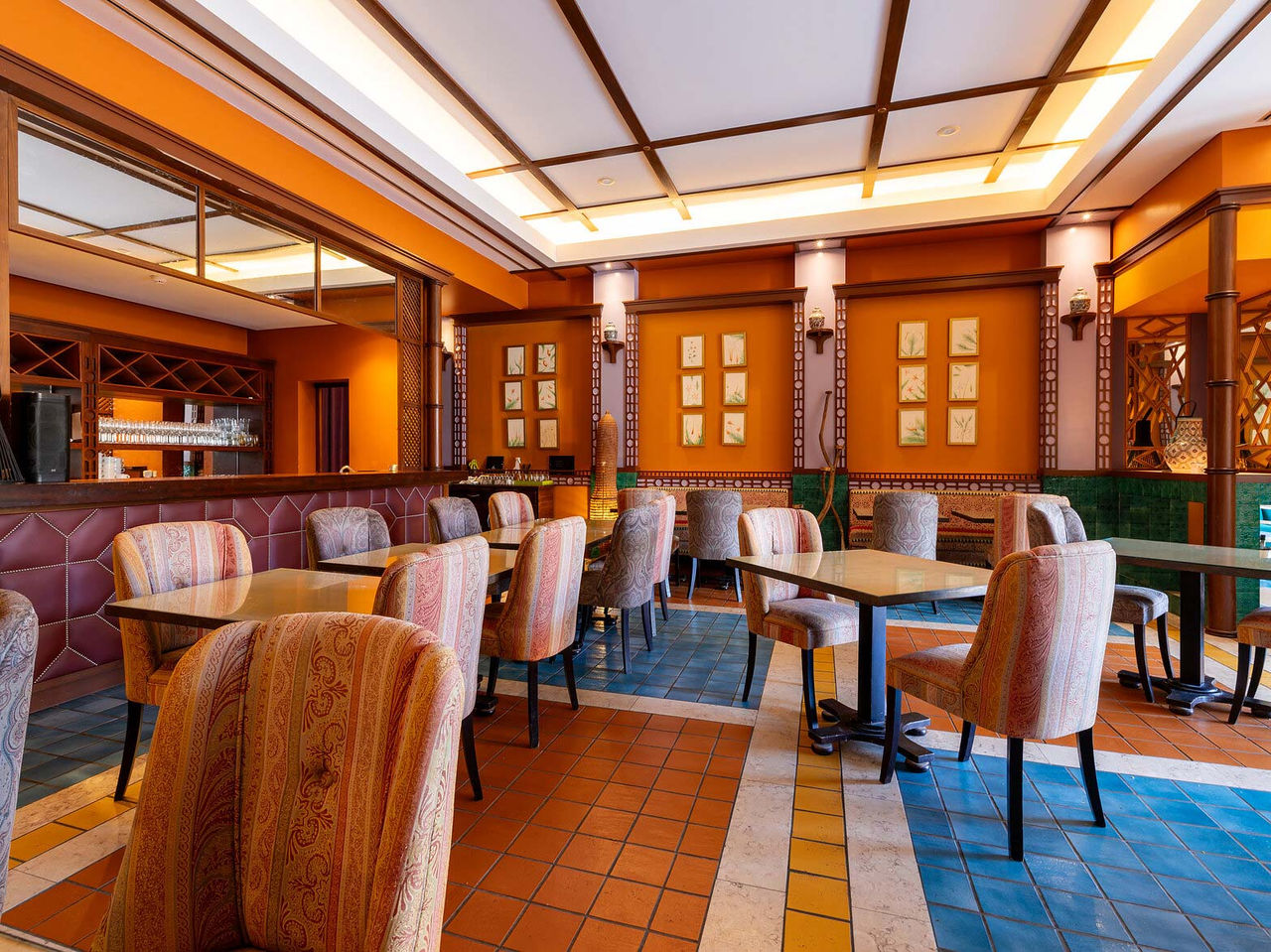 The Arab Magrebe restaurant at the 5-star Resort in Porto Santo features warm tones, square tables, and upholstered chairs.