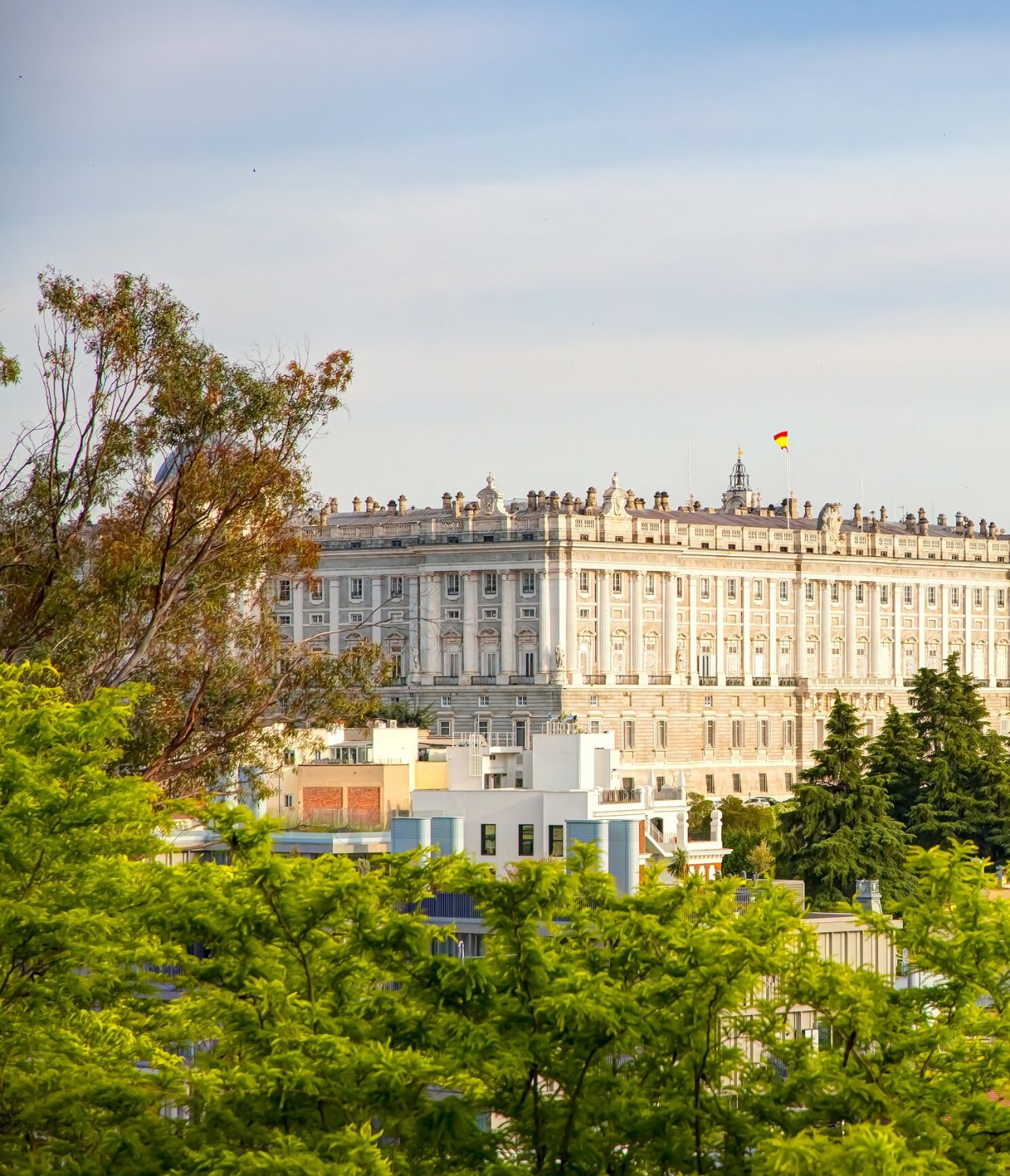 View of the Royal Palace in Madrid, a city heritage, surrounded by trees
