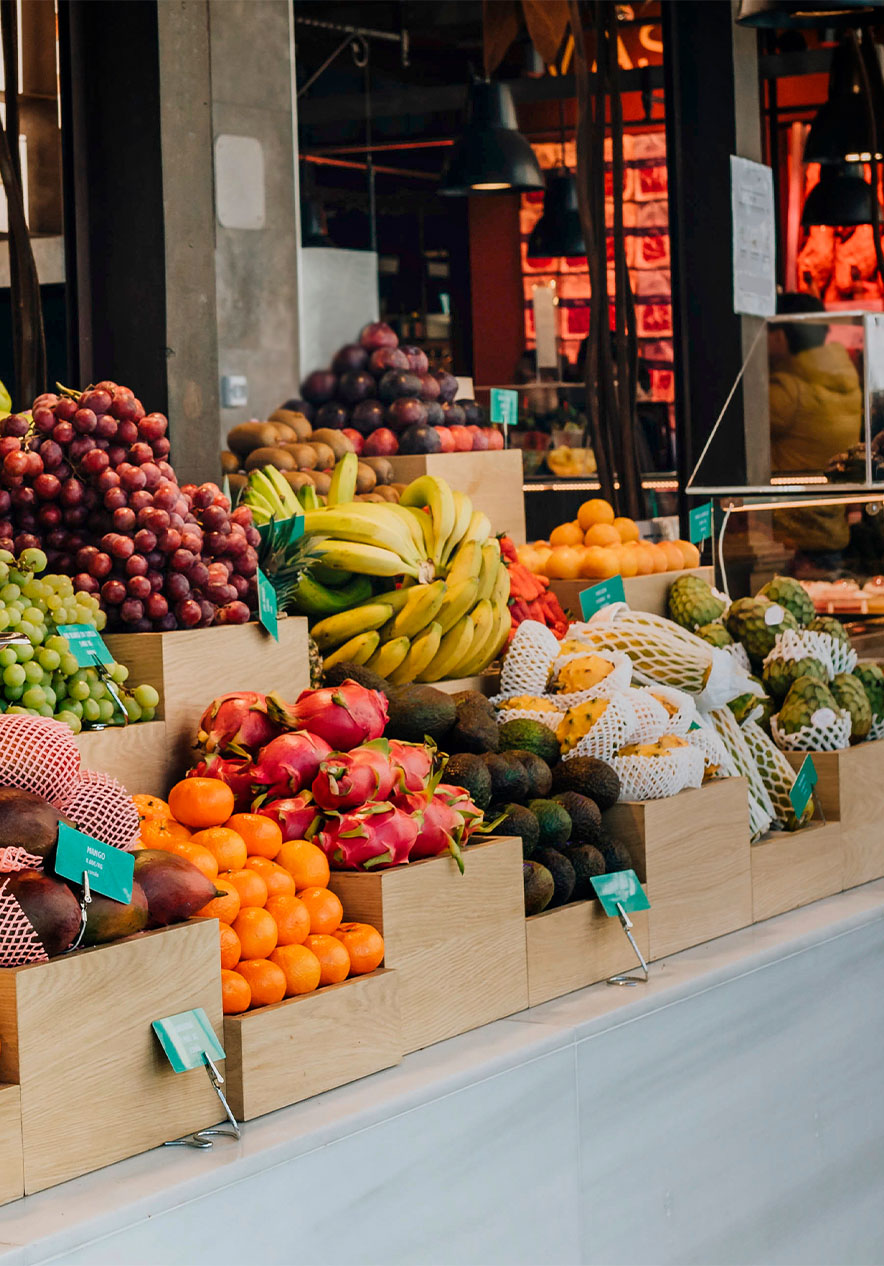 Stand with assorted fruits at Mercado de San Miguel with scales and black ceiling lamps with a glass counter