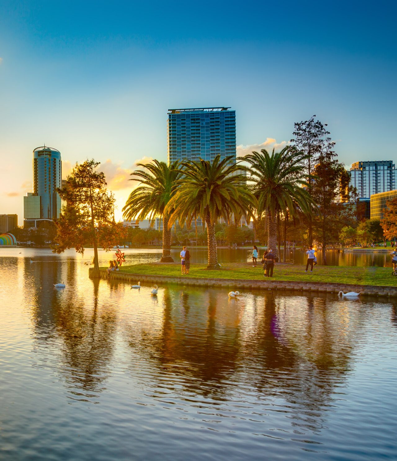 Panoramic view of Orlando, with a serene lake where the sunset reflects on the calm waters of the lake
