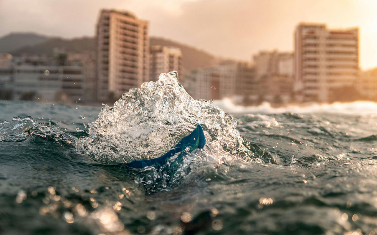 Explore Pestana Hotel Group featuring ocean waves splashing near a coastal skyline at sunset with distant towers