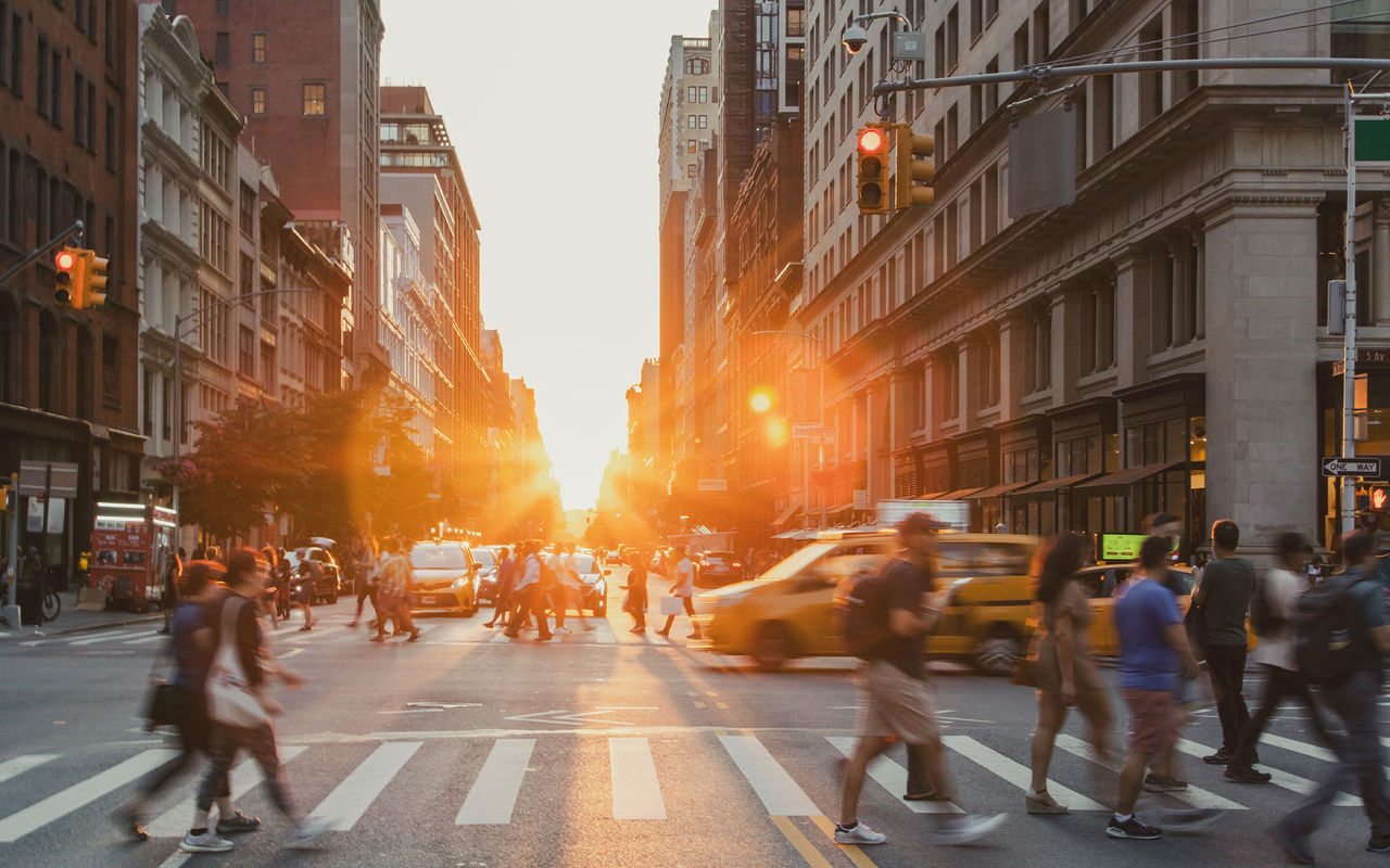 Explore Pestana Hotel Group featuring a busy city street at sunset with taxis and pedestrians crossing