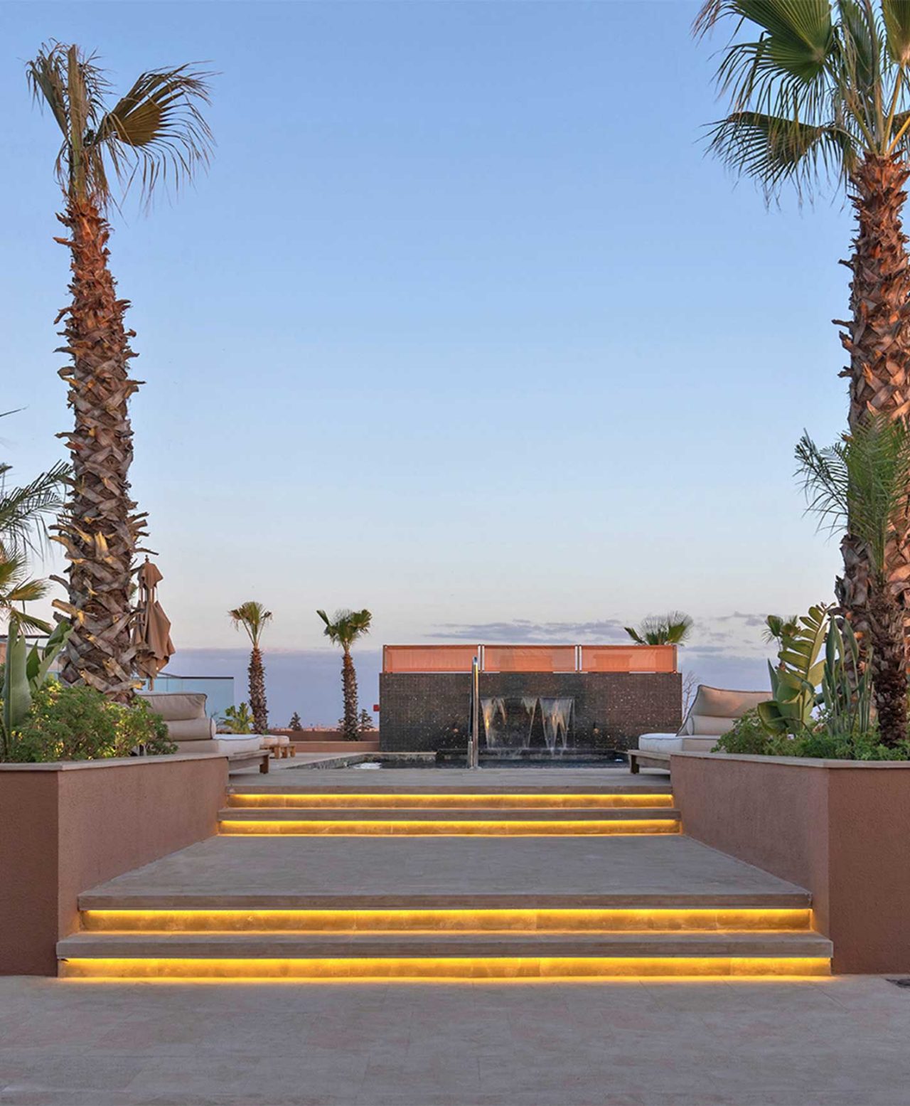 The brand Pestana CR7 Lifestyle Hotels featuring illuminated steps, palm trees and a sunset terrace pool