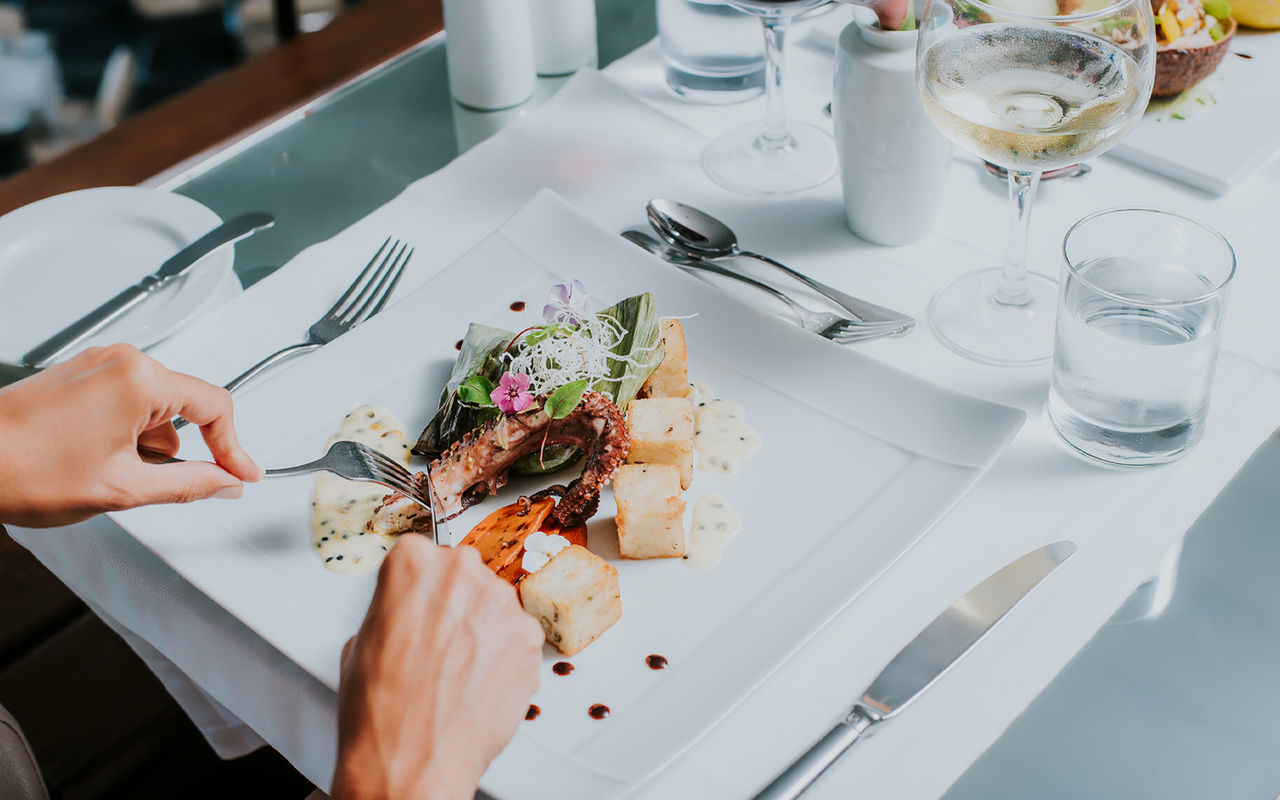 White plate with octopus and fried corn, during a meal at a Pestana Hotels and Resorts hotel